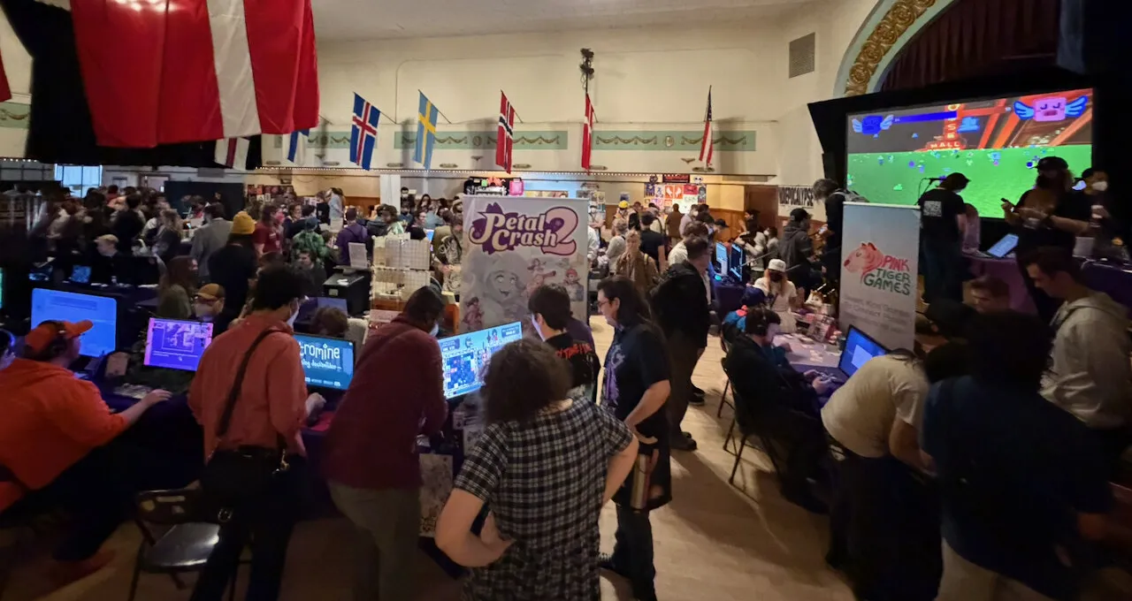 The PIGCon show floor, a packed historic hall hung with Nordic flags, the Plaza screen glowing at the top right
